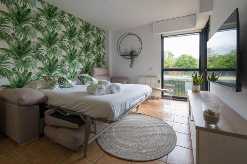 a bedroom with a bed and a large plant wall at Garden Fisterra - Jacuzzi, Jardín Privado y Vista Mar in Fisterra