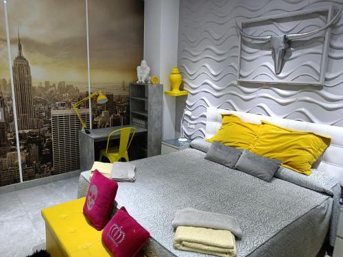 - une chambre dotée d'un grand lit avec des oreillers jaunes et roses dans l'établissement Sirenamar, à Torre del Mar