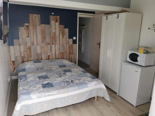 um quarto com uma cama e uma cabeceira em madeira em Chambre d'hôtes em Lunel