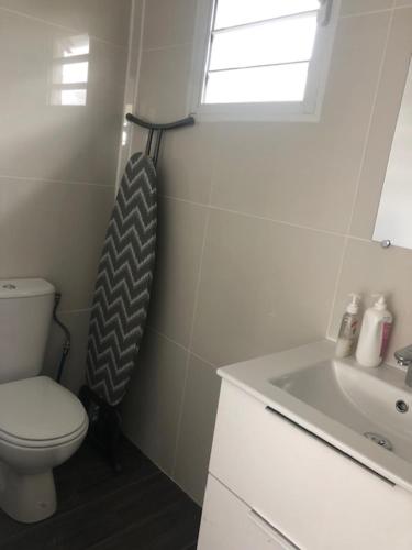 a bathroom with a toilet and a sink and a window at B. O. PARADIS SXM in Orient Bay