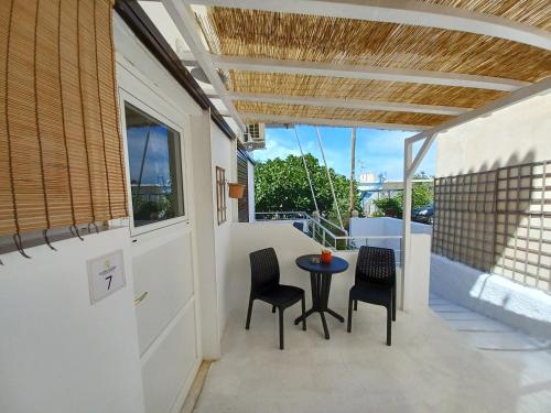 a patio with chairs and a table on a balcony at Koukounari 2 Rooms in Skala