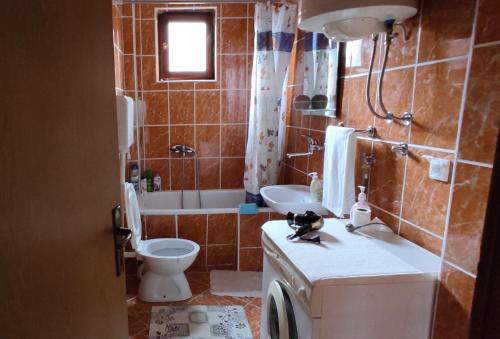 a bathroom with a tub and a toilet and a sink at Apartman Jovanović in Bajina Bašta