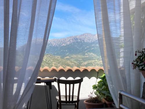 a view of a mountain from a balcony with a table and chairs at Canduleri in Orgosolo