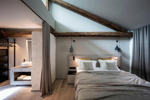 a bedroom with a large bed and a bathroom at Monastero Arx Vivendi in Arco