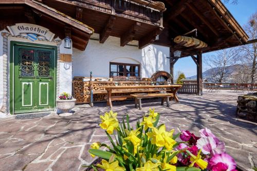 a patio with a green door and some flowers at Appartements Gasthof Schleifmühle Unterammergau in Unterammergau