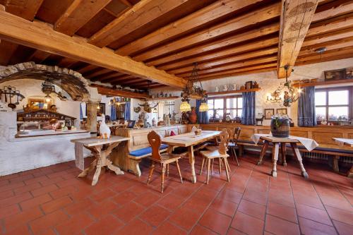 a large room with wooden ceilings and tables and chairs at Appartements Gasthof Schleifmühle Unterammergau in Unterammergau