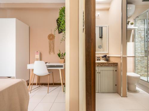een klein appartement met een bureau en een badkamer bij Villa Vaghi Rooms in Cagliari