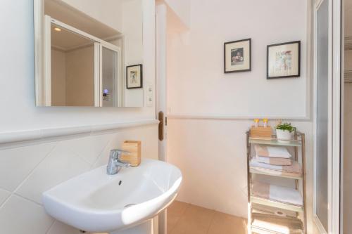 ein weißes Badezimmer mit einem Waschbecken und einem Spiegel in der Unterkunft Antonio's House in Sitges