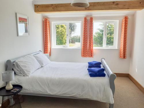 a bedroom with a bed and two windows at Valley View in St Austell