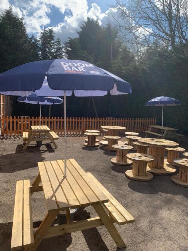 a group of picnic tables and an umbrella at Greenland's Inn in Longbridge
