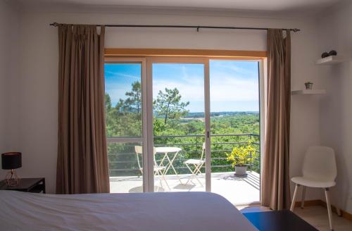 een slaapkamer met een bed en uitzicht op een balkon bij Casa Gemeos in Alcobaça
