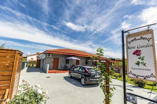 a car parked in a driveway in front of a house at Rose Garden Apartments in Mitikas