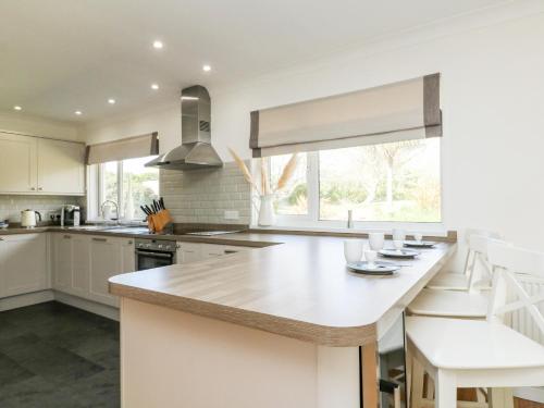 a kitchen with white cabinets and a large kitchen island at Seaport Lodge in Mawgan Porth