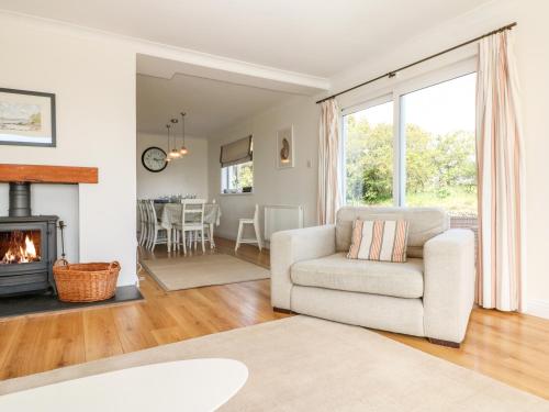 a living room with a chair and a fireplace at Seaport Lodge in Mawgan Porth