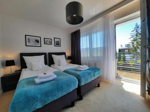 a bedroom with a bed and a large window at GoldenApart Willa -Apartamenty z dwiema sypialniami, basen in Krynica Morska