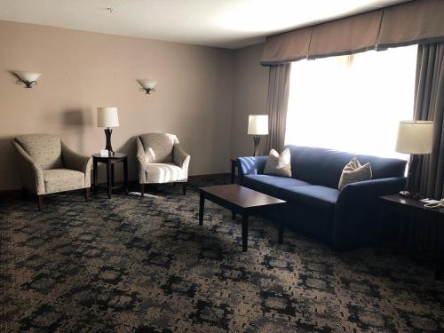 a living room with a blue couch and two chairs at Best Western Windsor Inn in Ashland