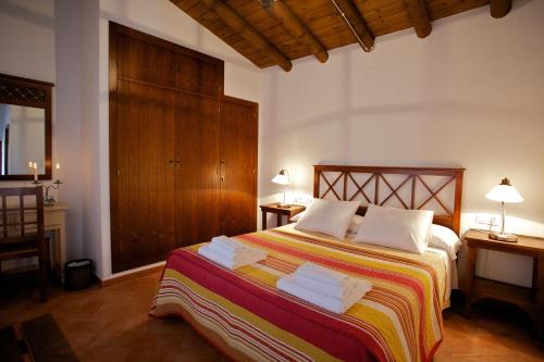 een slaapkamer met een bed met handdoeken erop bij Las Tobas in Higuera de la Sierra
