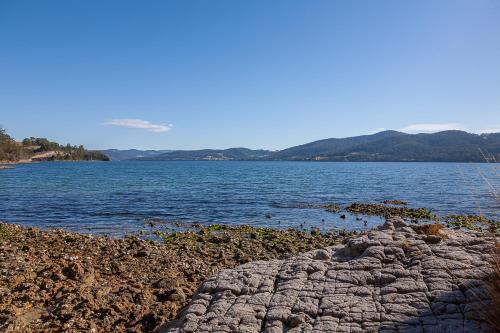 a large body of water with mountains in the background at Fairwinds Tasmania in Brooks Bay