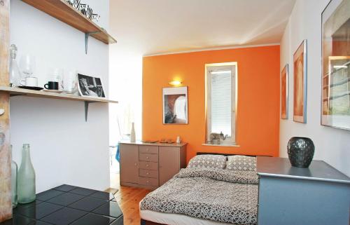 Schlafzimmer mit orangefarbenen Wänden, einem Bett und einem Schreibtisch in der Unterkunft Apartament Słoneczne Gniazdko z miejscem parkingowym GRATIS cena niższa przy pobycie od 6 dni in Sopot