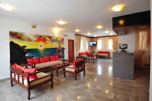 a living room with red furniture and a painting on the wall at Anna Ageliki in Damnoni