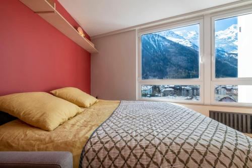 1 dormitorio con cama y ventana grande en Modern Studio With Mont Blanc View And Pool, en Chamonix-Mont-Blanc