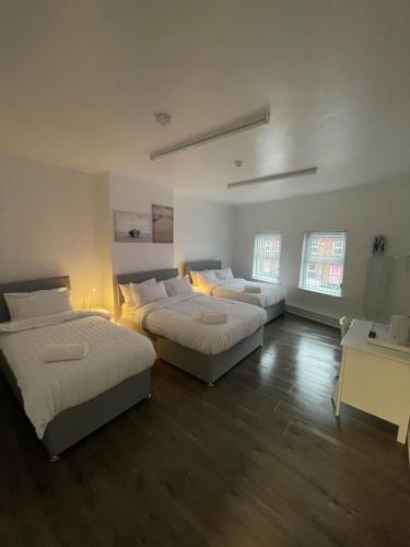a bedroom with two beds and a desk with a desk at County serviced accommodation in Liverpool