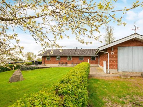 une maison en briques avec une pelouse verte devant elle dans l'établissement 6 person holiday home in Hejls, à Hejls