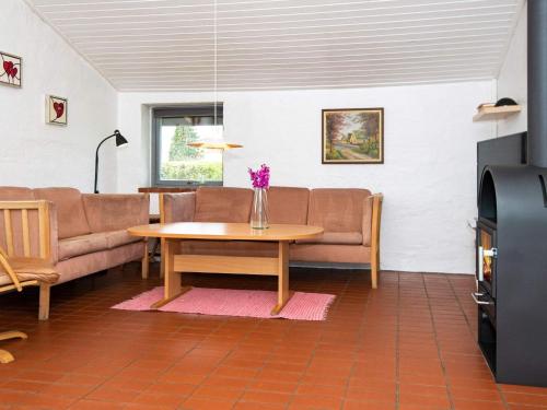 - un salon avec un canapé et une table fleurie dans l'établissement 6 person holiday home in Hejls, à Hejls