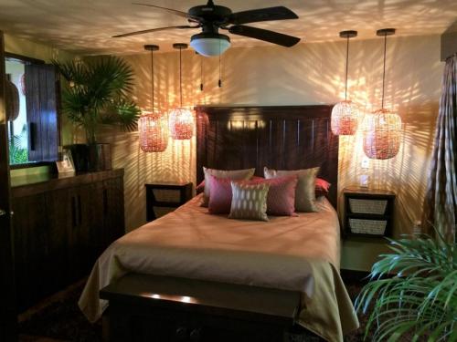 una camera da letto con letto, cuscini rosa e soffitto di Vista de las Rocas a Ixtapa