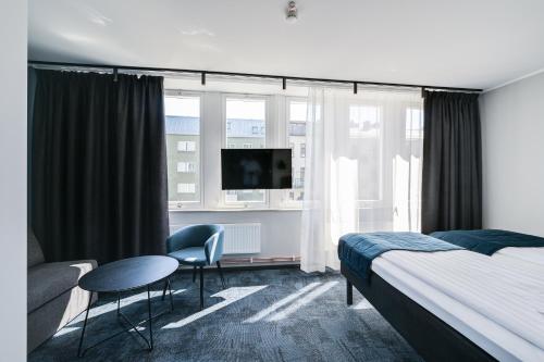 Habitación de hotel con cama, mesa y sillas en Hotel Fridhem, en Estocolmo