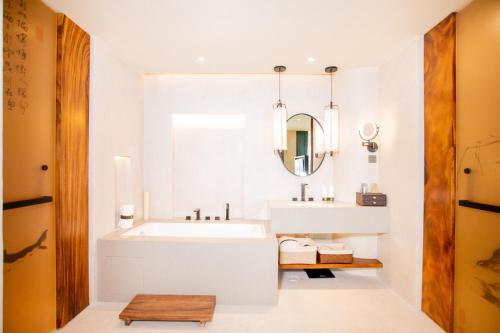 un bagno con un lavandino bianco e uno specchio di Jinling Onejoy Hotel a Nanjing