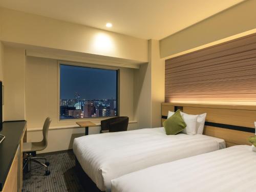 um quarto de hotel com duas camas e uma janela em ANA Crowne Plaza Sapporo, an IHG Hotel em Sapporo