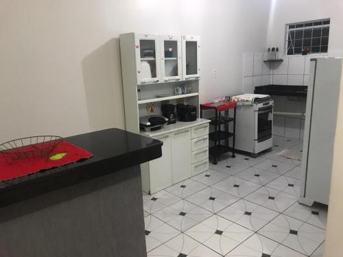 a kitchen with white appliances and black and white tiles at Olga Moreira 01 - inclui garagem in Paragominas