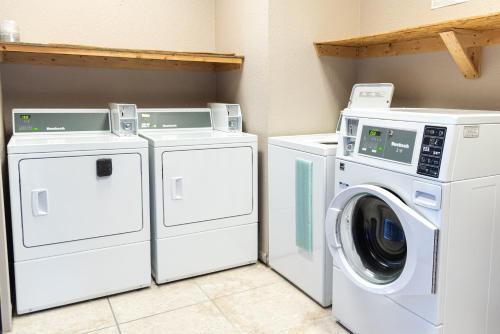two washing machines and a washer and dryer in a laundry room at Premium Inn and Suites in Killeen