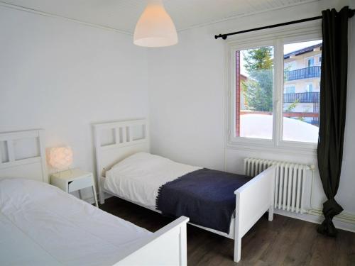 a white bedroom with two beds and a window at Appartement Les Deux Alpes, 5 pièces, 8 personnes - FR-1-348-242 in Les Deux Alpes