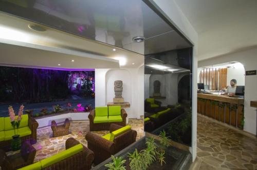 a lobby with green furniture and a large window at Hotel Bachue Girardot in Girardot