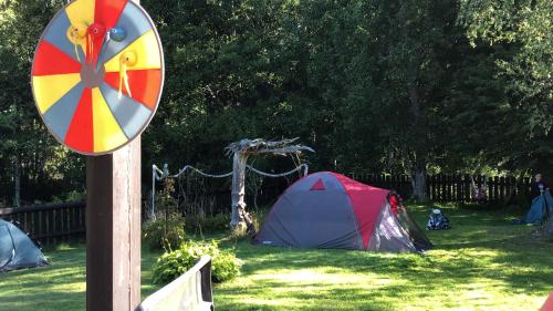 a sign with a tent in the grass next to some tents at Holiday Home NIGLINI in Saunags