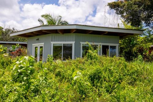 a small house in the middle of a field of grass at Kalani Oceanside Retreat in Pahoa