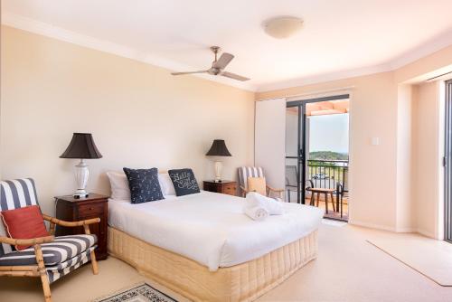 a bedroom with a bed and a balcony at Breakers 1 10 LJHooker Yamba in Yamba