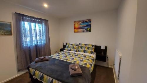 a small bedroom with a bed and a window at LAKE ESCAPE - Brand new warm and quiet two bedroom Apartment in Otematata