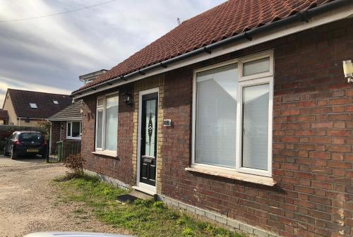 a brick house with a window on the side of it at Spacious double bedrooms sharing new bathroom, en-suite option available, Kings Lynn in Kings Lynn