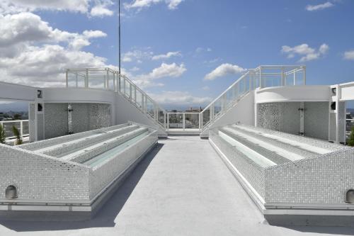 a bridge with two benches on top of a building at CRYSTAL ＆ RESORT FUKUOKA in Fukuoka