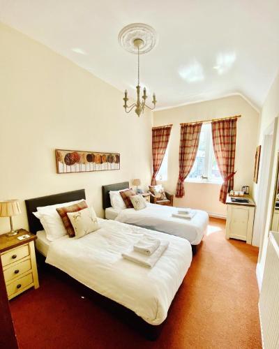 a bedroom with two beds and a chandelier at The Shoulder of Mutton in Bradwell