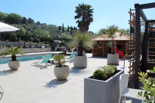 a patio with palm trees and a swimming pool at Luxury Zen in Châteauneuf