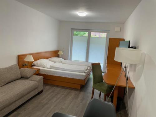 a bedroom with a bed and a couch and a desk at Stilvoll Wohnen in Oldenburg Kreyenbrück Apartments in Oldenburg