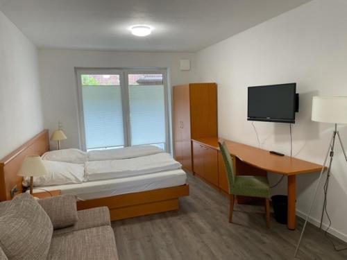 a bedroom with a bed and a desk and a tv at Stilvoll Wohnen in Oldenburg Kreyenbrück Apartments in Oldenburg