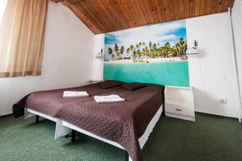 a bedroom with a bed with a painting of a beach at Pokoje Gościnne Korsarz in Ustka