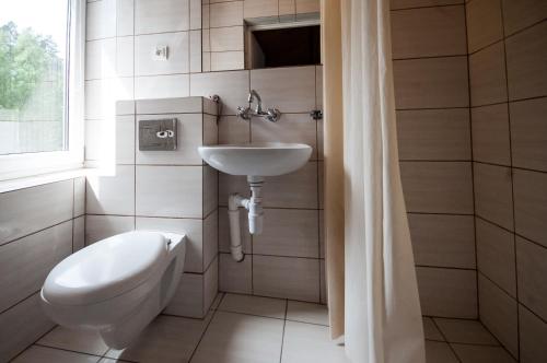 a bathroom with a toilet and a sink at Pokoje Gościnne Korsarz in Ustka