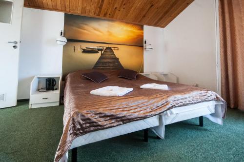 1 cama en una habitación con un cuadro en la pared en Pokoje Gościnne Korsarz, en Ustka