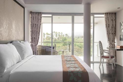 a bedroom with a large bed and a large window at Lembang Views in Lembang